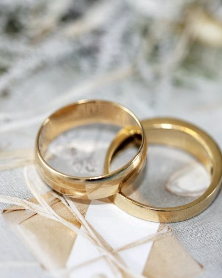 gold wedding band on white textile