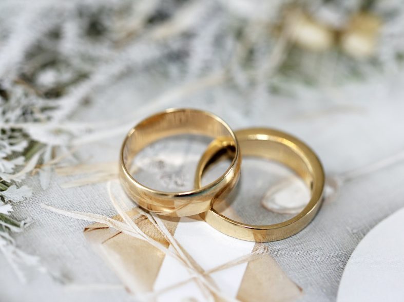 gold wedding band on white textile